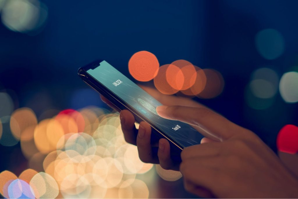 person putting finger on phone to scan fingerprint